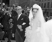 Marina Fanfani, con abito da sposa di Maria Antonelli, accompagnata all’altare dal padre Amintore il giorno delle nozze con Massimo Londei. Roma, 30.6.1962